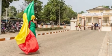 متظاهرة تحمل علم بنين أمام البرلمان